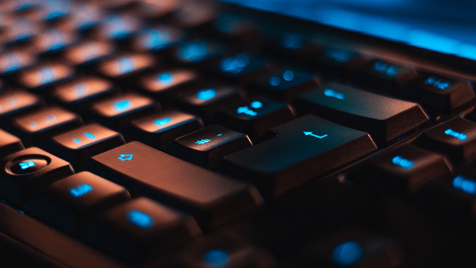 Close-up of a backlit mechanical keyboard with blue lighting