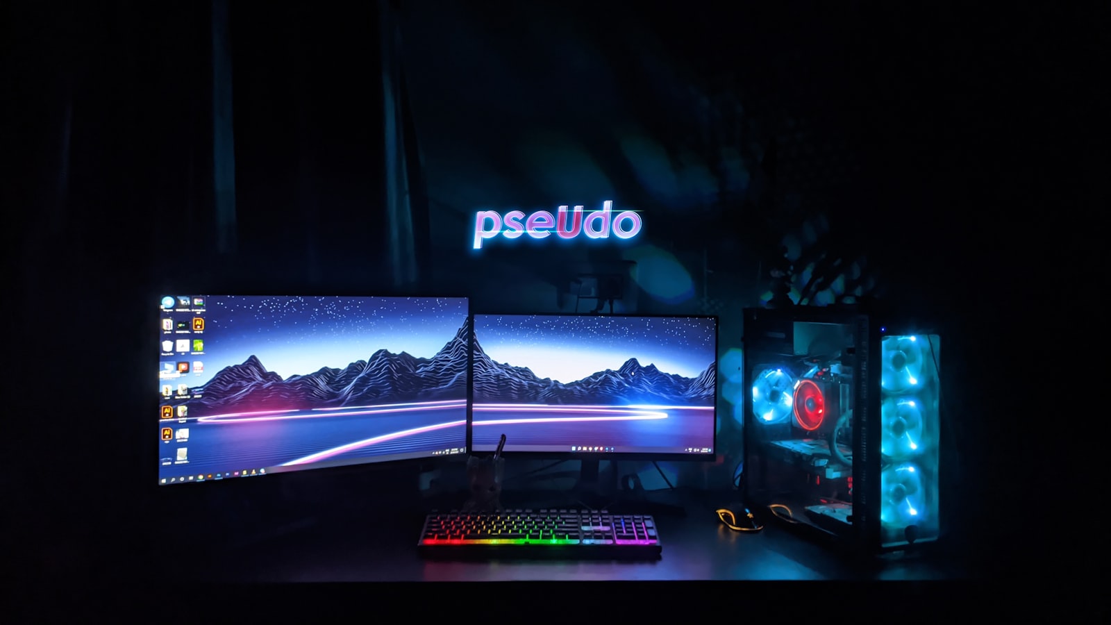 A dual-monitor desk setup with RGB keyboard and blue PC case lighting
